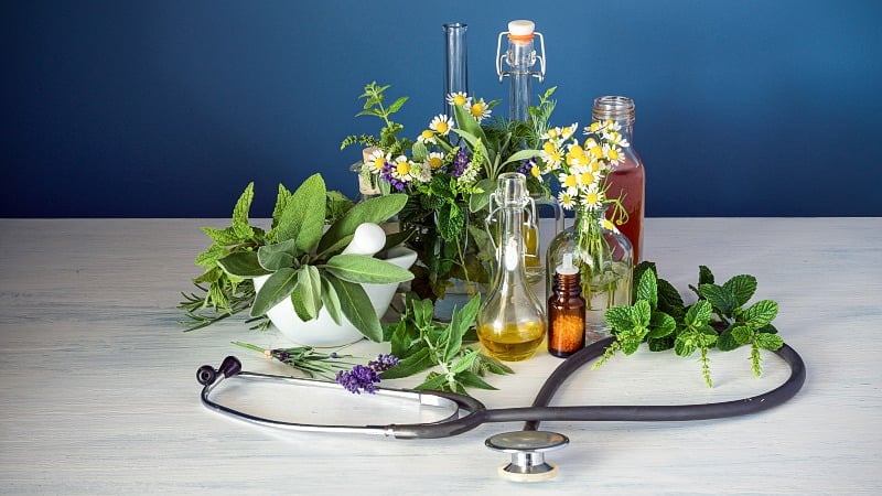 Different plants and flowers with terpenes oil extracts in bottles and a stethoscope
